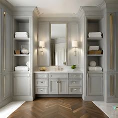 a bathroom with white cabinets and wood floors