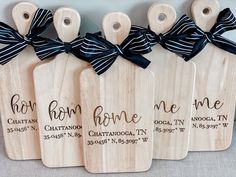 four wooden tags with black ribbons tied to them