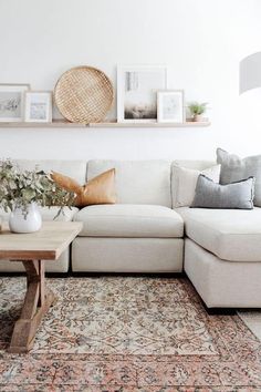 a living room with a couch, coffee table and pictures on the wall above it