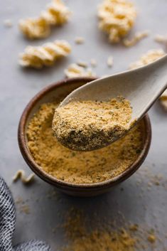 a spoon full of mustard sits in a bowl