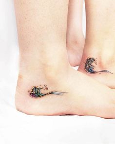 two people with matching tattoos on their feet, one has a wave and the other has a fish