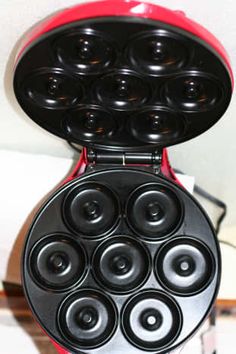 a red and black electric device sitting on top of a white table next to a wall