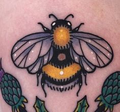 a tattoo with a bee and two fish on it