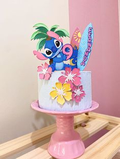 there is a cake decorated with an image of stitchy and flowers on the top