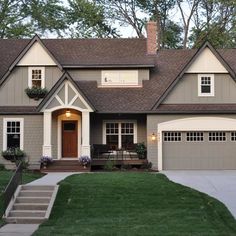 a gray house with white trim and brown roof