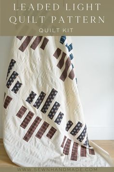 a white quilt with black and brown designs on it