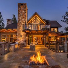 a fire pit in front of a large house