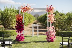 an outdoor ceremony set up with flowers and chairs