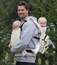 a man carrying a baby in a sling