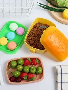 there are many different foods in the bowls on the table, including fruit and dog treats