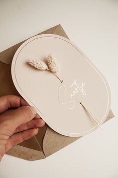 a person is holding a card that says stay sweet on it and two white feathers are sticking out of it