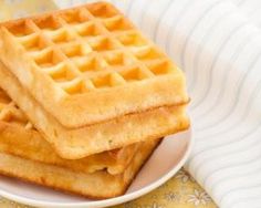 three waffles stacked on top of each other on a plate next to a napkin