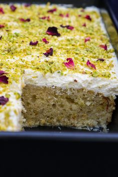 a cake with white frosting and pink flowers on it's edges is cut into pieces