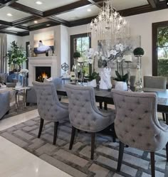 a formal dining room with chandelier and couches in front of the fireplace