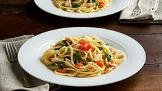 two white plates filled with pasta and vegetables