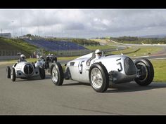 two vintage race cars driving on a track