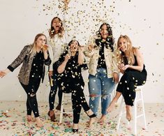 a group of women standing next to each other under confetti