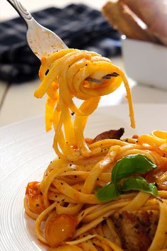 a fork full of spaghetti with meat and tomato sauce on the plate, ready to be eaten