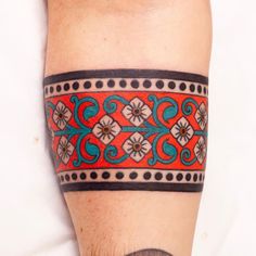 a tattoo on the leg of a person with an orange and blue design on it