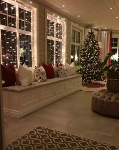 a living room filled with lots of furniture and christmas lights on the windows sill