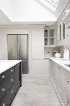 a kitchen with white cabinets and gray drawers