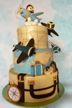 a three tiered cake with an airplane and luggage theme on the top, sitting on a green plate