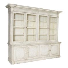 an old white bookcase with glass doors on the top and bottom shelves, isolated against a white background