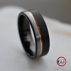 a black and gold wedding ring with two tone inlays on the inside of it