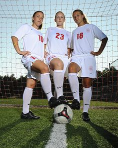 three female soccer players are posing for a photo