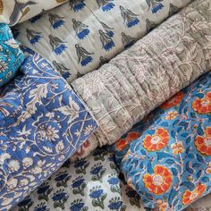 a pile of different colored and patterned fabrics on top of each other in various patterns