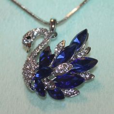 Nwt: Beautiful Swan Necklace With Blue & Clear Rhinestones, It Also Has Clear Crystals On His Head & Neck. 18" Silver Plated Chain, 1 3/4" High Swan Blue Necklaces With Sparkling Stones For Anniversary, Elegant Blue Rhinestone Necklace Gift, Blue Rhinestone Jewelry For Gifts, Elegant Blue Rhinestone Necklace With Sparkling Stones, Elegant Blue Crystal Rhinestone Necklace, Blue Crystal Necklaces With Bling, Blue Crystal Jewelry With Bling, Blue Crystal Necklaces With Diamond Accents, Blue Crystal Necklace With Diamond Accents