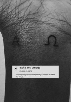 a person's arm with the word alpha and omega written on it in black ink