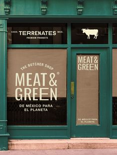 a green store front with two signs on the windows that read meat and green, de mexico para el planeta