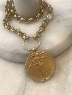 This beautiful statement necklace features an Angel medallion pendant with detailing on both and is 1.5 inches in diameter. It is antique gold plated. It hangs on a textured 8mm rolo chain in clear electroplated brass. Flower CZ connector adds a nice detail to the chain. It is offered in three length sizes: 16, 17 and 18. Choose from the menu. Lobster clasp. 🎁All orders are shipped in a box or a cloth pouch. Gift messages are attached to the box. Cheap Bronze Medallion Necklaces, Cloth Pouch, Gold Angel, Medallion Necklace, Rolo Chain, Gorgeous Necklaces, Star Necklace, Chain Styles, Antique Gold