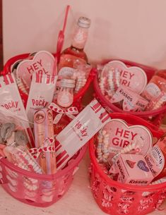 two red baskets filled with lots of different items next to each other on top of a table