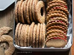 a tin filled with lots of cookies next to other items on top of a wooden table