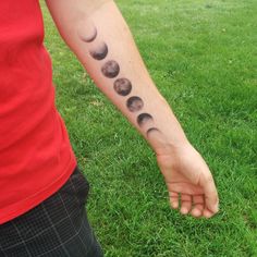 a person with a tattoo on their arm that shows phases of the moon