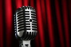 an old - fashioned microphone with red curtains in the background