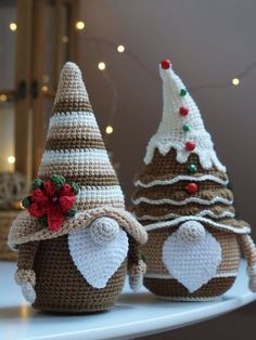 three crocheted christmas trees sitting on top of a white shelf next to each other