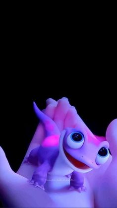 a close up of a toy gecko in the dark