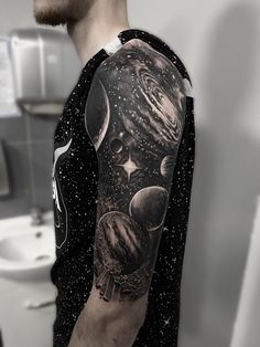 a man's arm with an image of the planets and stars on it in black and white