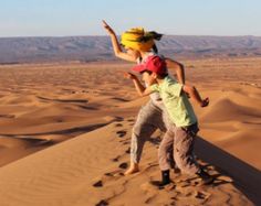 two children playing in the desert sand dunes