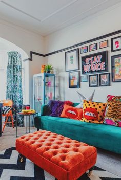 a living room filled with colorful furniture and pictures on the wall above it's headboard