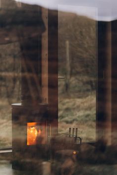 a fire place sitting in the middle of a window next to a chair and table