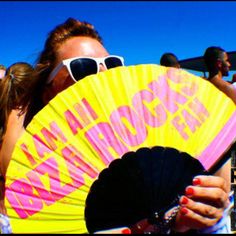 a woman holding a fan in front of her face