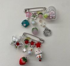 a bunch of charms sitting on top of a white table next to an apple and other items