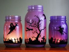 three jars with halloween decorations painted on them, one is purple and the other is pink