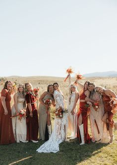 a group of women standing next to each other on top of a grass covered field