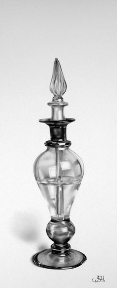 a clear glass vase with a black top on a white surface, in the shape of a candle holder