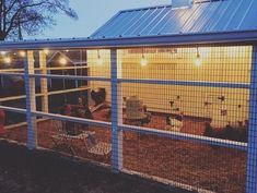 a chicken coop with lights on the roof and chickens in it's cages